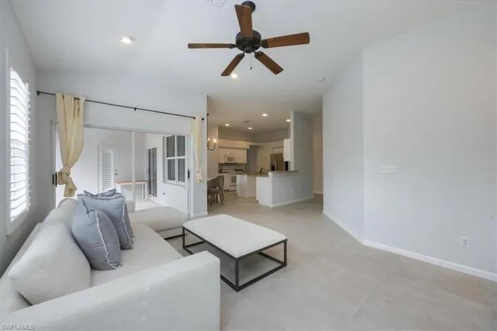 Living room featuring ceiling fan, recessed lighting, and lofted ceiling