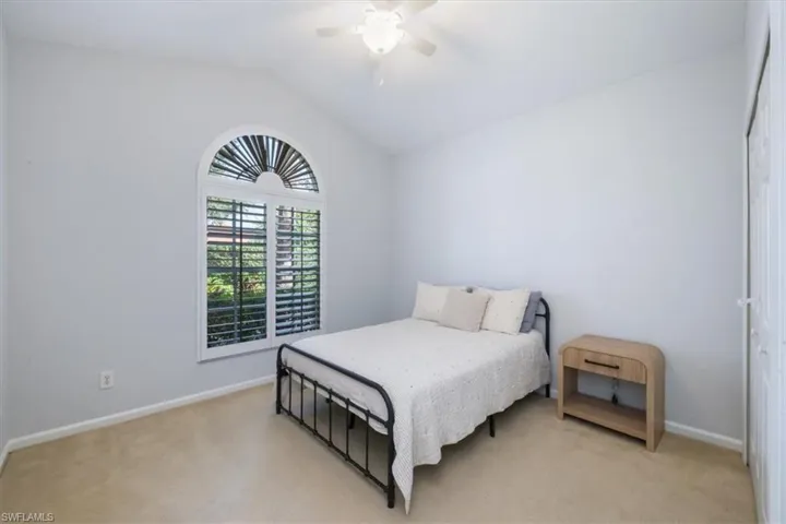 Bedroom with vaulted ceiling, a closet, carpet floors, and ceiling fan