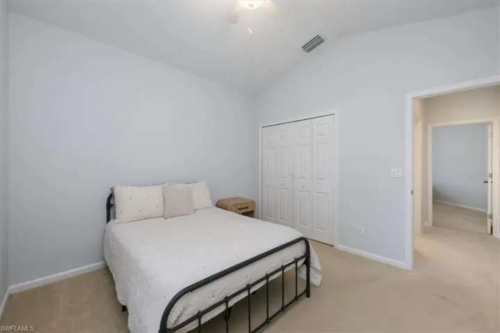 Bedroom featuring vaulted ceiling, a closet, light colored carpet, and a ceiling fan
