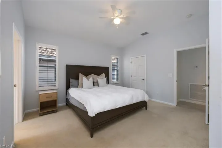 Carpeted bedroom with a ceiling fan and baseboards