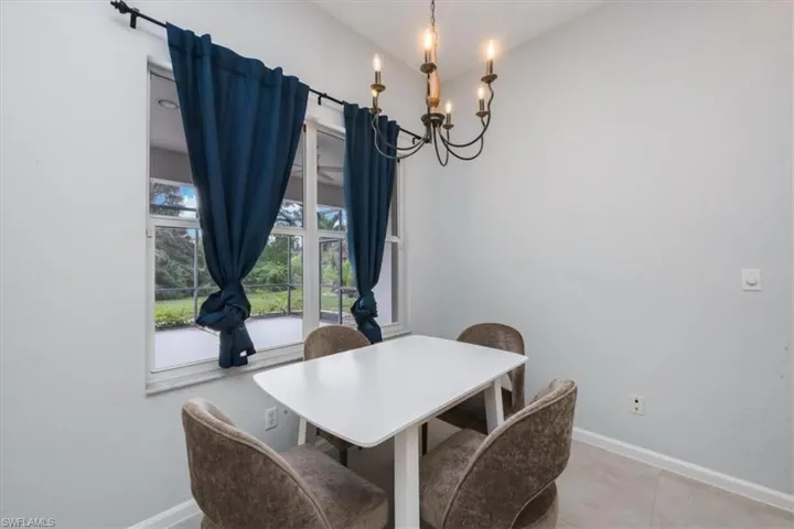 Dining area featuring a chandelier, lofted ceiling, and light tile patterned floors