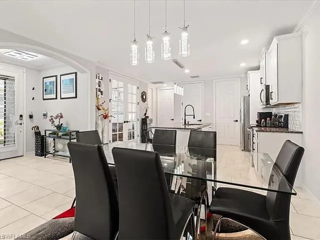 Dining space with light tile patterned flooring, french doors, crown molding, arched walkways, and recessed lighting