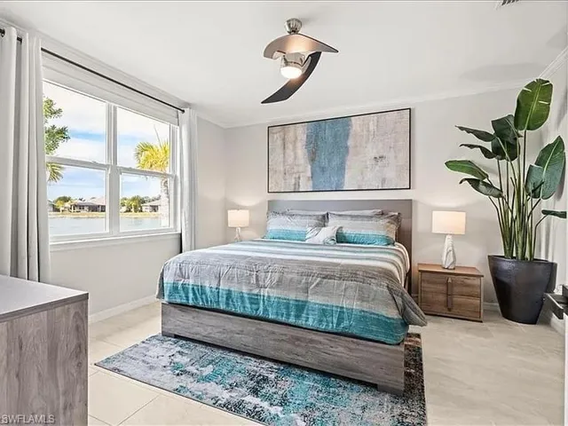 Bedroom featuring crown molding, ceiling fan, and light tile patterned floors