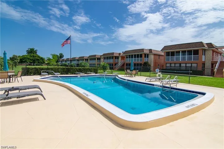 Outdoor swimming pool with integrated steps, surrounded by a light-toned paved deck