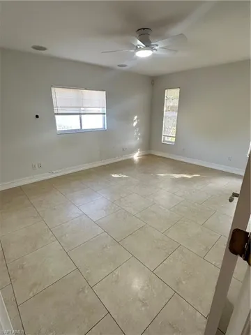 Unfurnished room with baseboards and ceiling fan