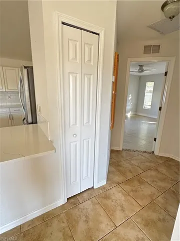 Corridor with light tile patterned floors and baseboards