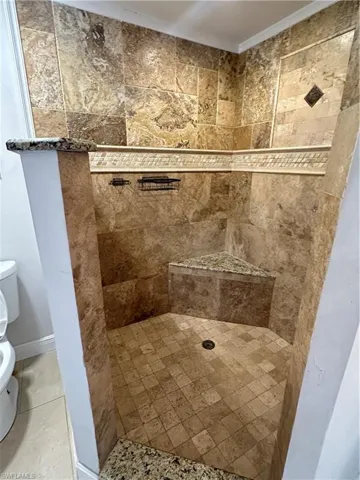 Full bathroom with toilet and a shower stall