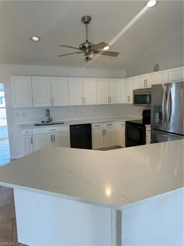 Kitchen featuring white cabinets, white refrigerator, range, recessed lighting, and dishwasher