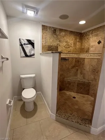 Bathroom featuring a shower stall, recessed lighting, and light tile patterned floors