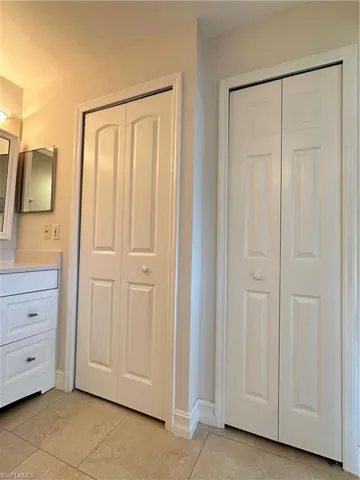 Unfurnished bedroom with light tile patterned floors and two closets