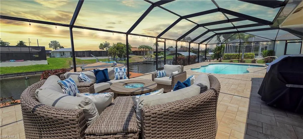 Screened lanai featuring a swimming pool, paved deck, and waterfront canal access