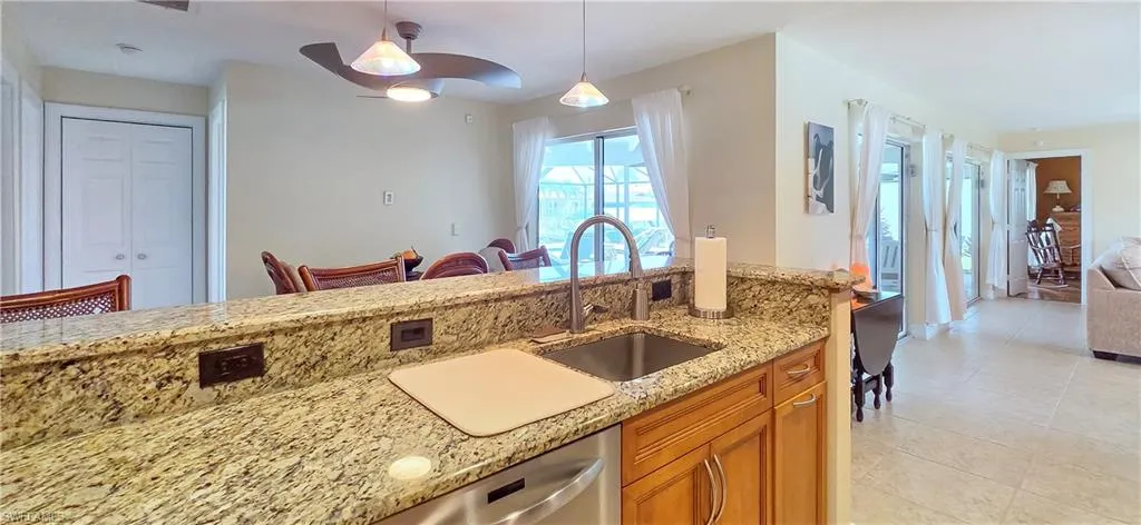 Kitchen featuring granite countertops, wood cabinetry, stainless steel sink with gooseneck faucet, and recessed lighting