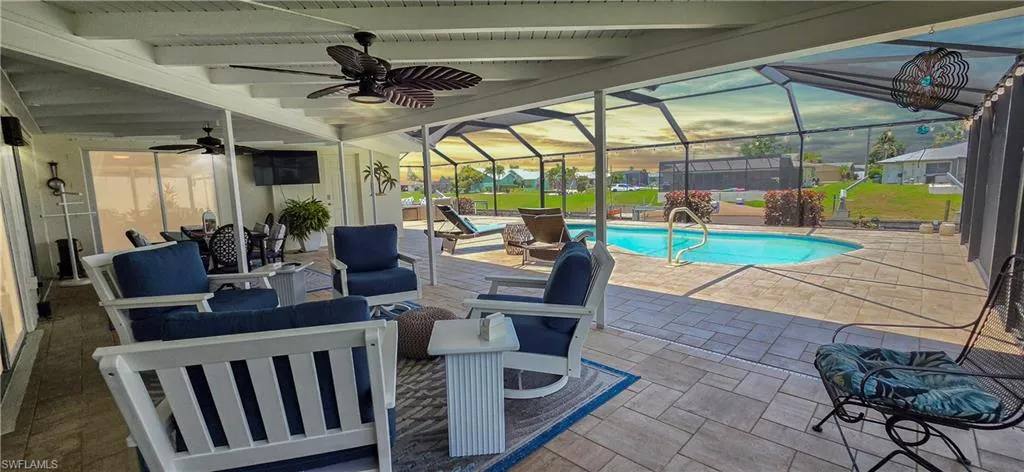 Spacious screened-in lanai with a covered patio area, ceiling fans, and a built-in swimming pool