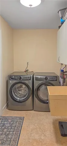 Utility room featuring light beige walls and a patterned tile floor