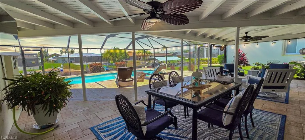 Screened lanai featuring a paver patio, exposed beam ceiling, and dual ceiling fans