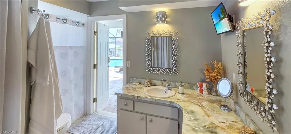 Bathroom featuring a vanity with an integrated sink, a large counter space, and an ornate framed mirror