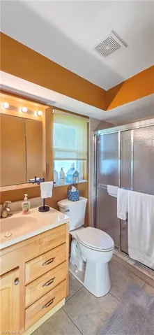 Full bathroom featuring a single vanity with wood cabinetry, a mirrored medicine cabinet, and a shower with a sliding glass door