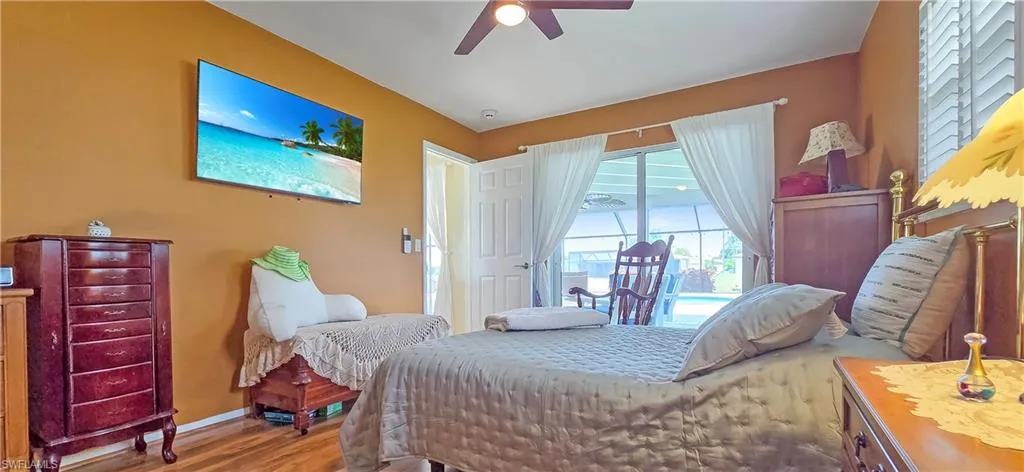 Interior room featuring wood-finish flooring, a ceiling fan with light, and direct access to an outdoor area via sliding glass doors