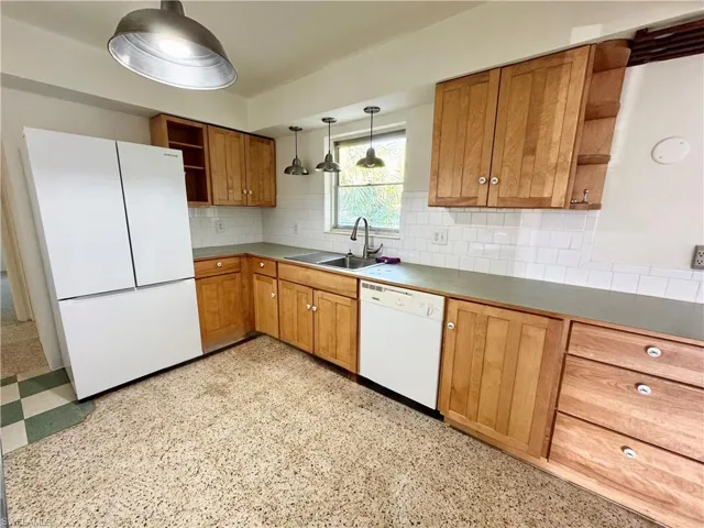 Kitchen with open shelves, tasteful backsplash, wood cabinetry, a sink, and white appliances