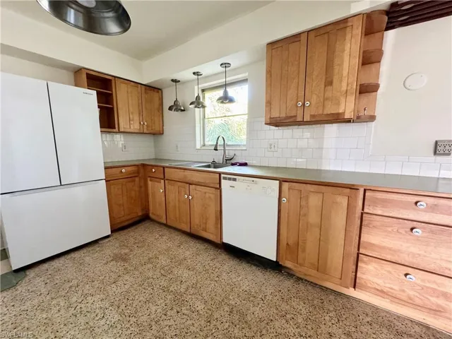 Kitchen featuring white appliances, open shelves, a sink, and wood cabinetry