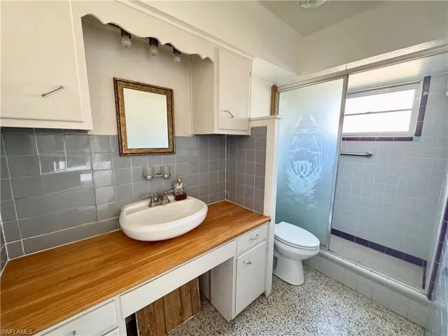 Bathroom featuring vanity, a shower and  toilet