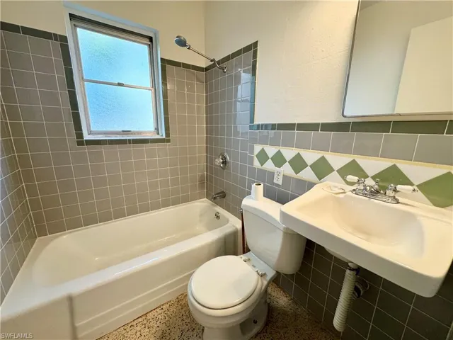 Full bathroom 2 with tiled walls, and shower / bathing tub combination