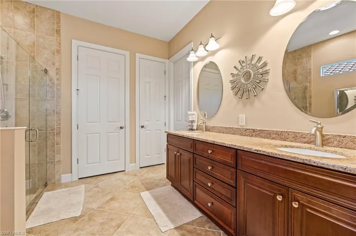 Bathroom featuring tile patterned flooring, vanity, and a shower with shower door