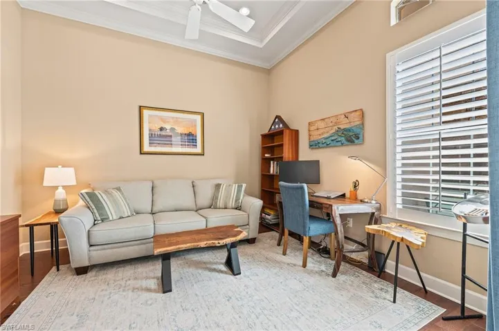 Home office with ceiling fan, light hardwood / wood-style flooring, and ornamental molding