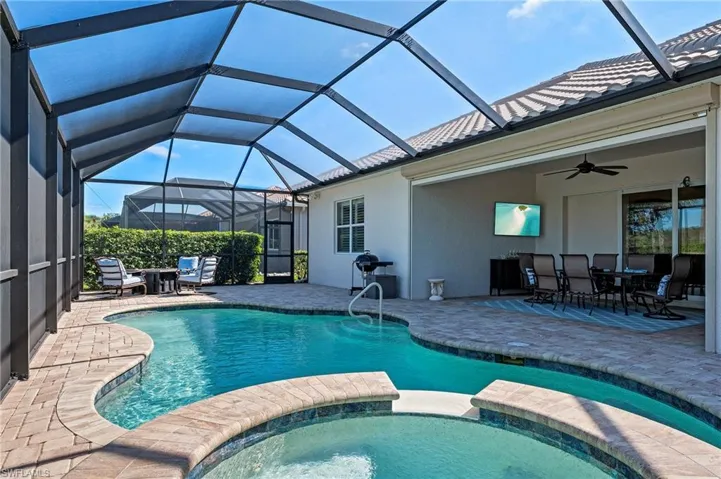 View of pool featuring a lanai, ceiling fan, and a patio area