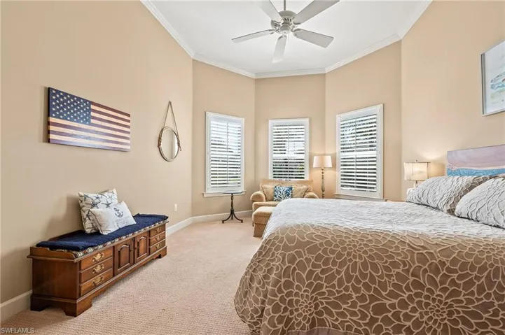 Bedroom featuring light carpet, ceiling fan, and crown molding
