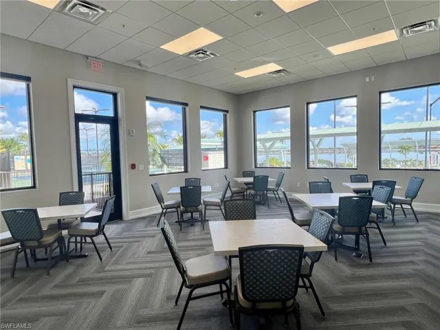 Dining room featuring a drop ceiling, carpet floors, and a healthy amount of sunlight