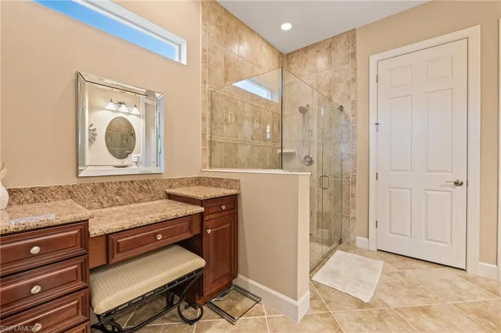 Bathroom featuring tile patterned floors, vanity, and a shower with shower door