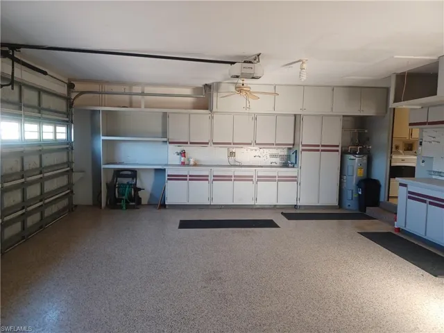 Garage featuring water heater and a garage door opener