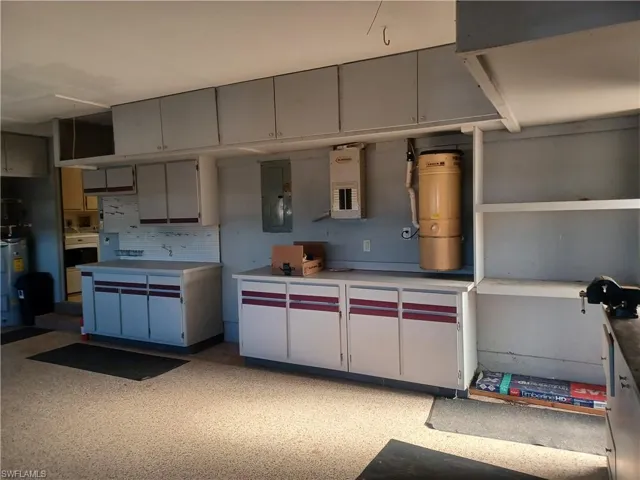 Kitchen with backsplash, electric panel, light flooring, and light countertops