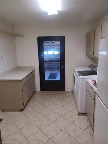 Laundry room featuring cabinet space, washing machine and clothes dryer, and light tile patterned floors