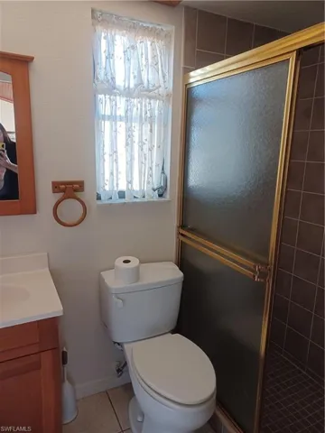 Bathroom featuring a stall shower, vanity, and light tile patterned flooring