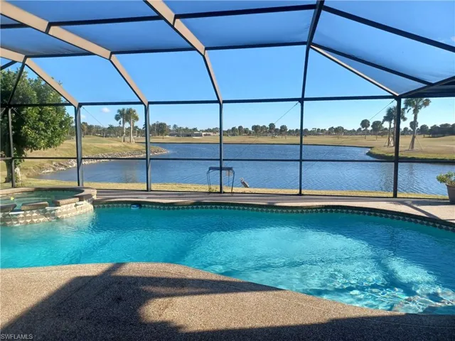Combined pool / hot tub with a sunroom, a lanai, and a water view