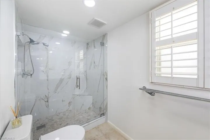 Bathroom with baseboards, visible vents, a marble finish shower, recessed lighting, and toilet