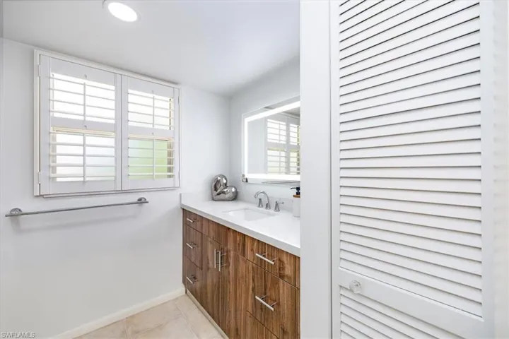 Bathroom with tile patterned flooring, vanity, and baseboards