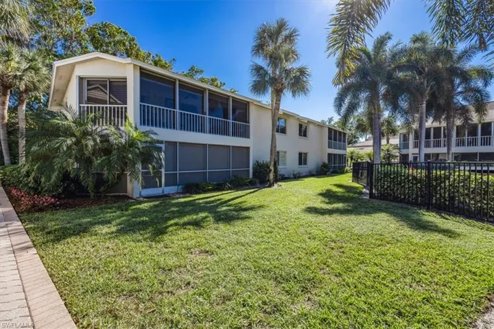 View of yard featuring a sunroom and fence