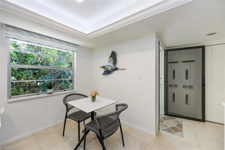 Dining area with a tray ceiling, baseboards, and light tile patterned flooring