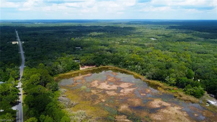 Aerial view of property and surrounding area with a forest