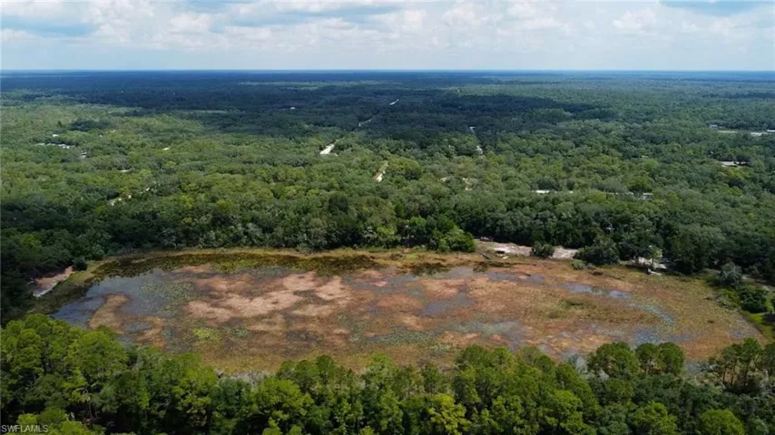 Aerial view of property's location with a heavily wooded area
