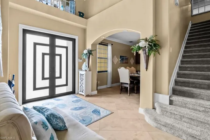 Welcoming entry with a striking double door and a staircase featuring carpeted steps
