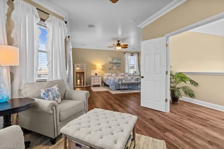 Spacious room featuring hardwood style flooring, neutral wall colors, and crown molding