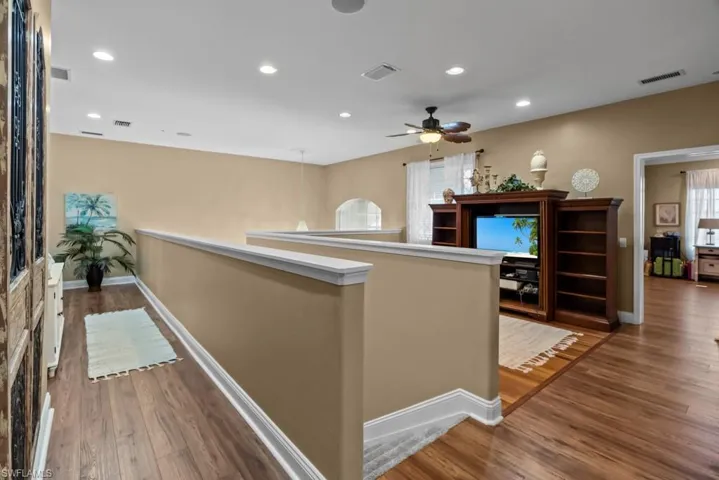 The property features an open-concept living area with wood flooring and recessed lighting