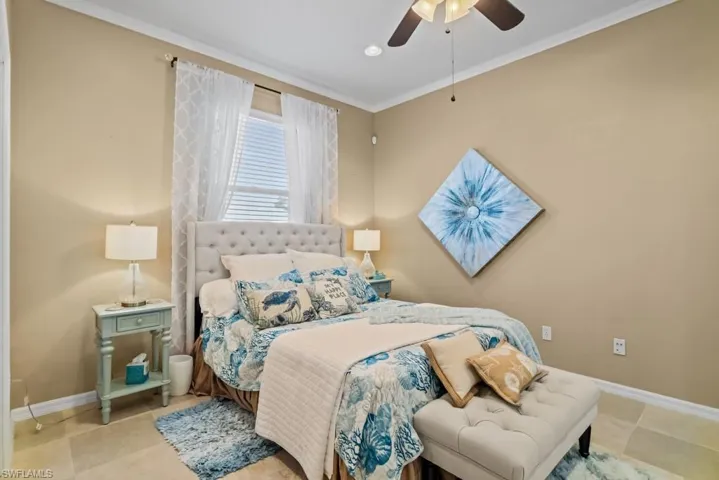 This room features a window with blinds and sheer curtains, a ceiling fan, and crown molding