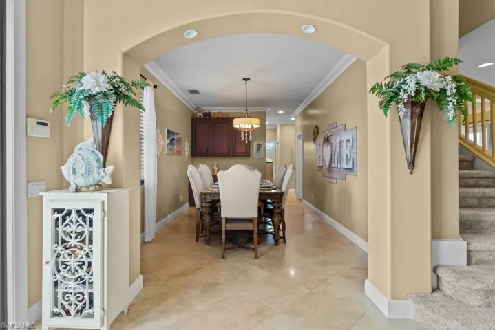 This inviting dining area features a decorative chandelier, recessed lighting, and tile flooring