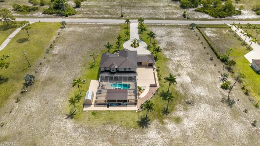 The property features a large house with a private pool, a screened enclosure, and a circular driveway