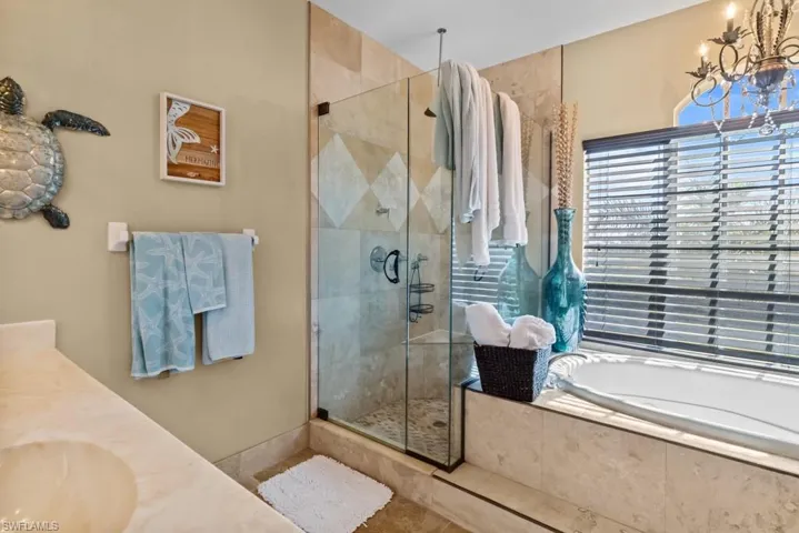 The bathroom features a spacious walk-in shower with a glass enclosure and a built-in bathtub with tiled surround